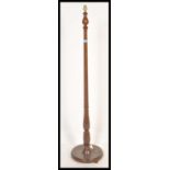 A vintage 20th Century mahogany standard lamp, raised on a circular base with turned upright column.