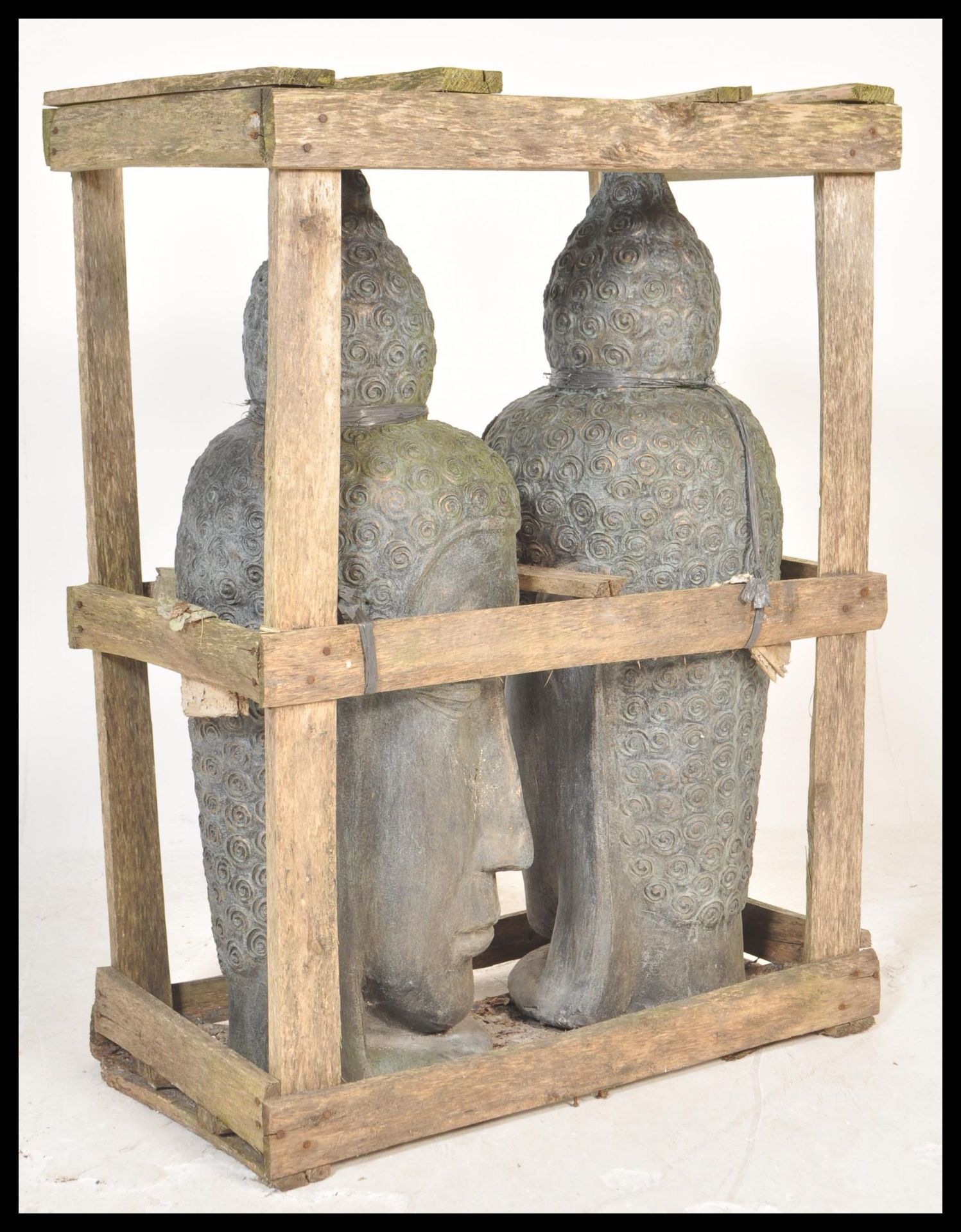 Two 20th Century terracotta Asian deity / buddha sculptural heads of large proportions being set