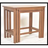 A vintage retro 20th Century teak wood nest of tables. The graduating nest of three tables raised on