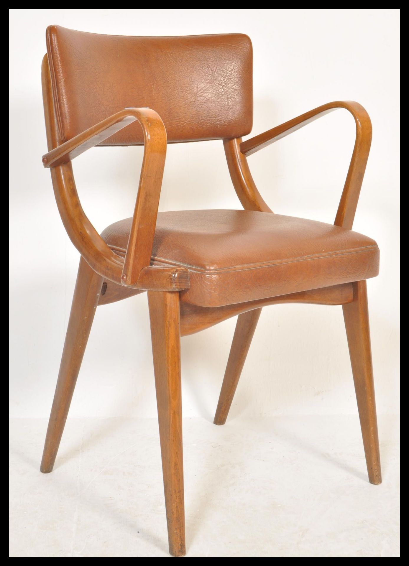 A vintage retro 20th Century Ben Chairs armchair raised on shaped angular legs with leather / faux