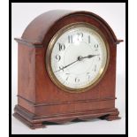 A 20th Century mantel clock having a mahogany case of domed form with a round white enamelled