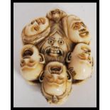 A 20th Century Japanese netsuke or toggle of composite ivory or bone effect in the Twelve Faces