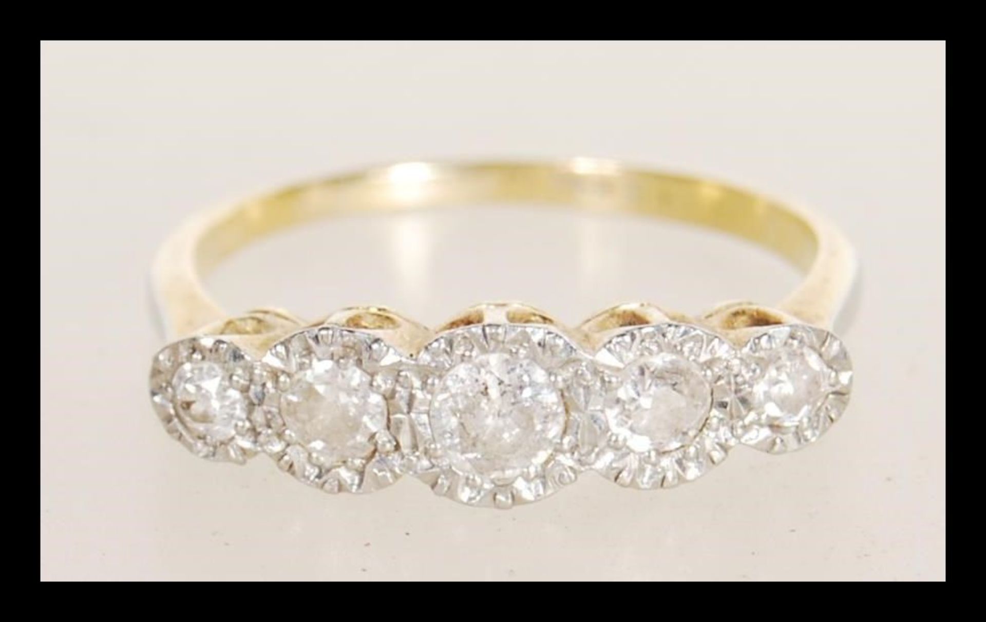 An early 20th century stamped 18ct gold ring illusion set with five brilliant cut diamonds.