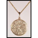 A 9ct gold round shaped hallmarked locket with engine turned decoration being set to a 9ct gold