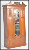An early 20th Century Edwardian walnut single armoire wardrobe having a central bevelled glass