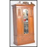 An early 20th Century Edwardian walnut single armoire wardrobe having a central bevelled glass