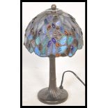 A Tiffany style table lamp having a leaded stained glass shade with blue glass panels and glass