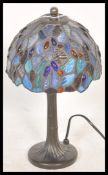 A Tiffany style table lamp having a leaded stained glass shade with blue glass panels and glass