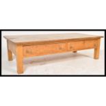 A large 20th Century scrubbed pine farmhouse coffee table, fitted with long frieze drawers with