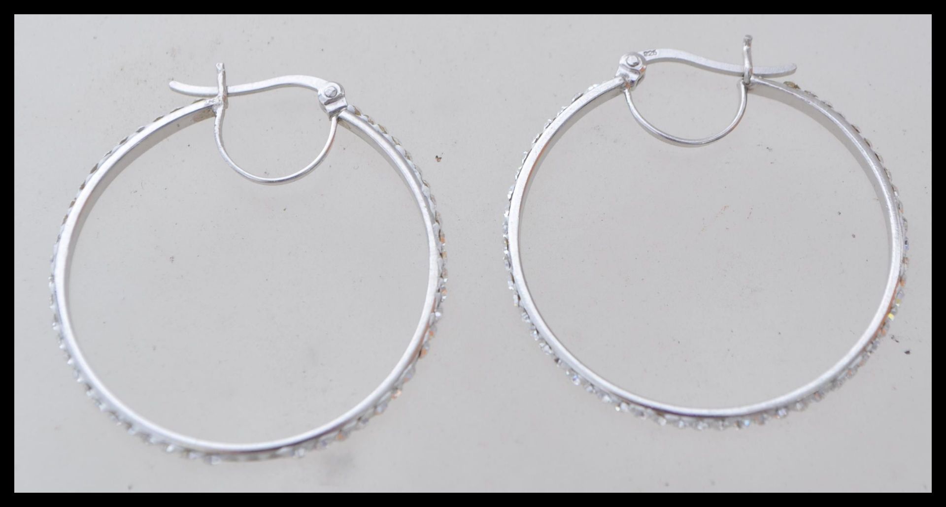 A pair of stamped 925 silver hoop earrings being set with cz's to the exterior. Weight 2.8g.