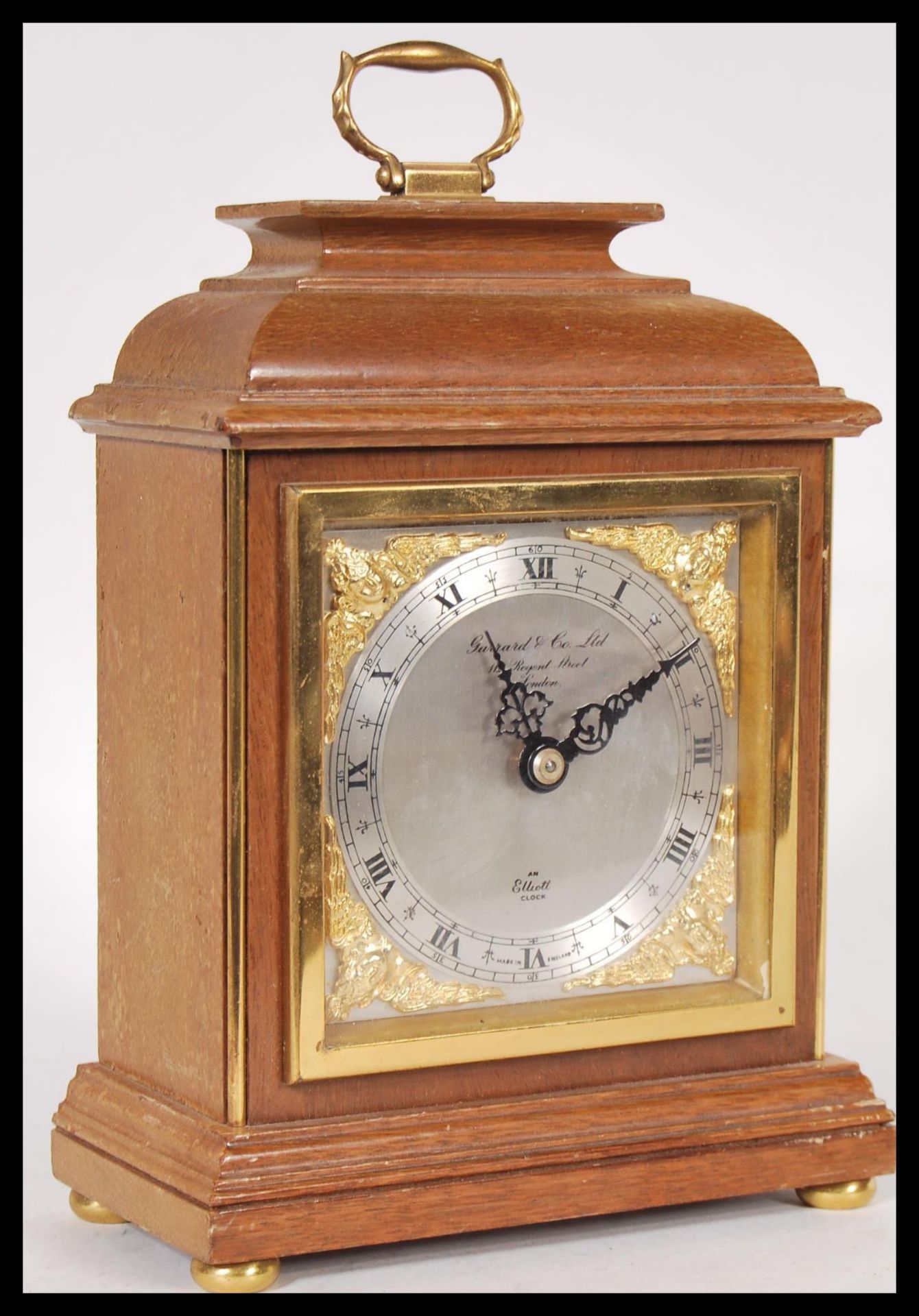 A 20th Century Elliot mantel clock retailed by Garrard & Co Ltd, having a silvered face with roman