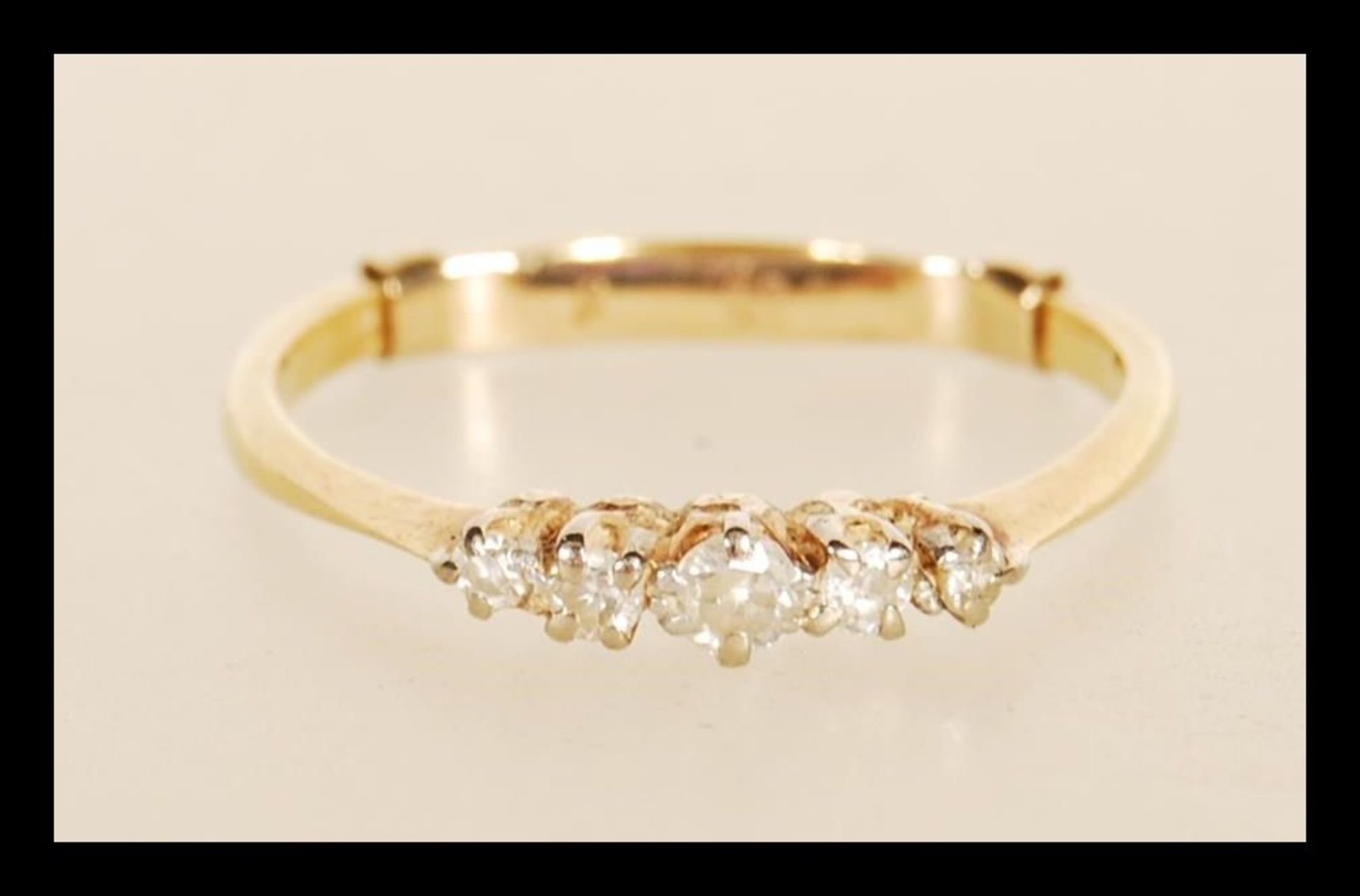 A stamped 18ct gold ring prong set with five diamonds, with a stamped 9ct size adjuster. Weight 2.