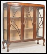An early 20th Century Queen Anne revival mahogany display cabinet having three astragal glazed doors