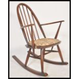 A vintage retro 20th Century Ercol spindle back rocking chair having a hooped back and a fitted seat