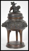 A 19th Century Chinese bronze censer ding incense burner raised on circular base with Foo dog mask