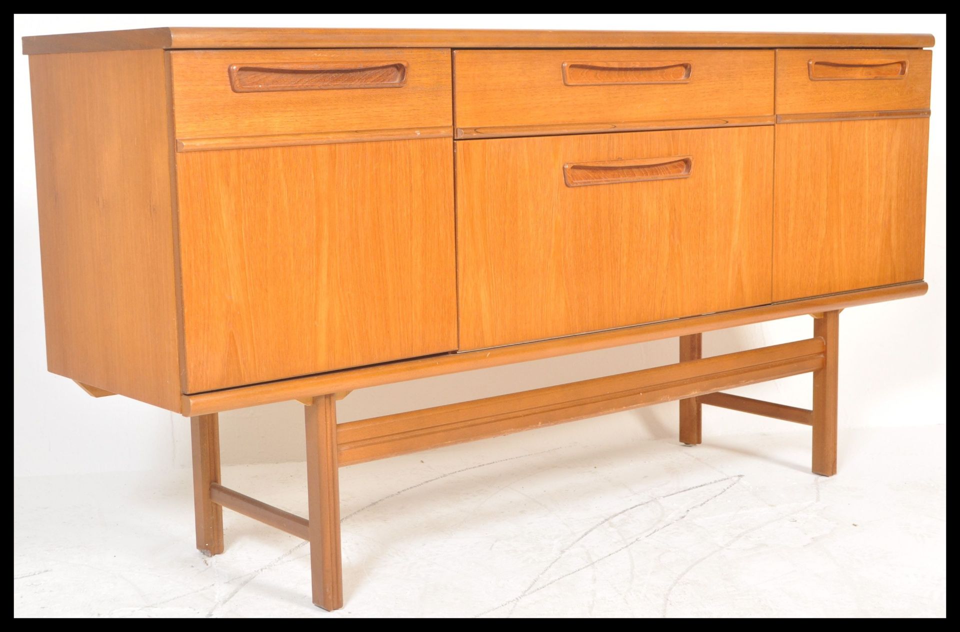 A retro 20th Century teak wood sideboard / credenza by Nathan,having a configuration of drawers