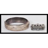 A vintage hallmarked silver bangle bracelet having half engraved floral decoration with hidden clasp