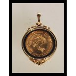 A 9ct gold necklace pendant inset with a 1/10 South African gold Krugerrand coin dated 1985. Total