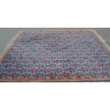 A very large 20th century floor carpet rug having a blue ground with central medallions, pink floral