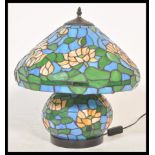 A large Tiffany style table tamp having a large leaded stained glass bulbous body and matching