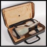 An early 20th Century hallmarked silver three piece travelling vanity set consisting of brushes