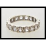 A stamped 9ct white gold eternity ring set with white stones. Tests as 9ct. Weight 3.5g. Size M.