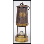 A vintage early 20th Century miner's safety lamp, applied plaque reading Paterson Lamps Ltd of
