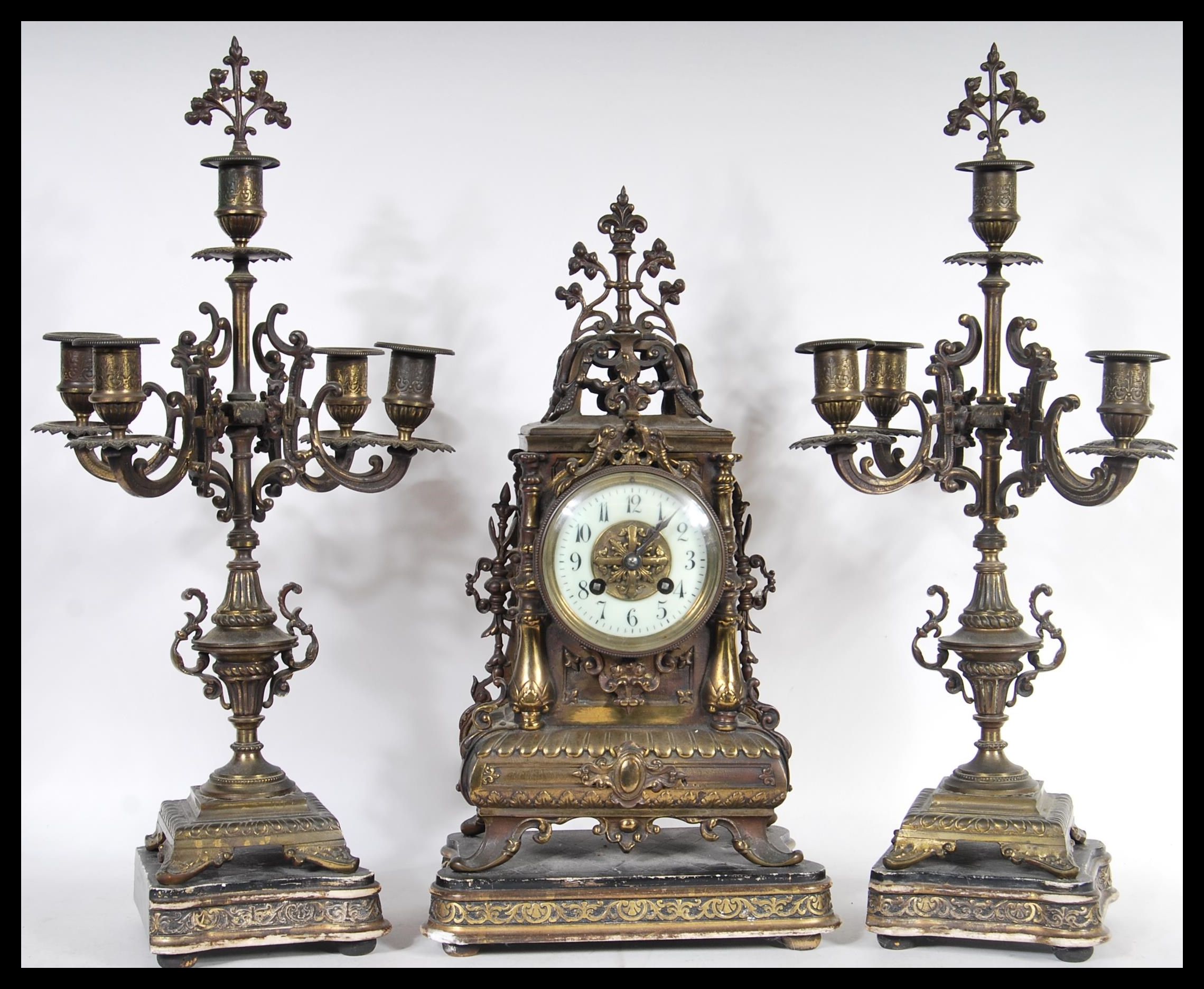 A 19th Century Victorian clock and garniture set consisting of a brass mantel clock having gilt