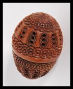 A 19th Century treen carved coquilla nut, the nut carved for use as a nutmeg grinder holder, the