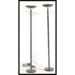 A pair of 20th Century ebonised tubular up-lighter standard floor lights / lamps being raised on