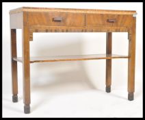 A 20th Century Art Deco walnut console table being raised on square legs with two drawers to the