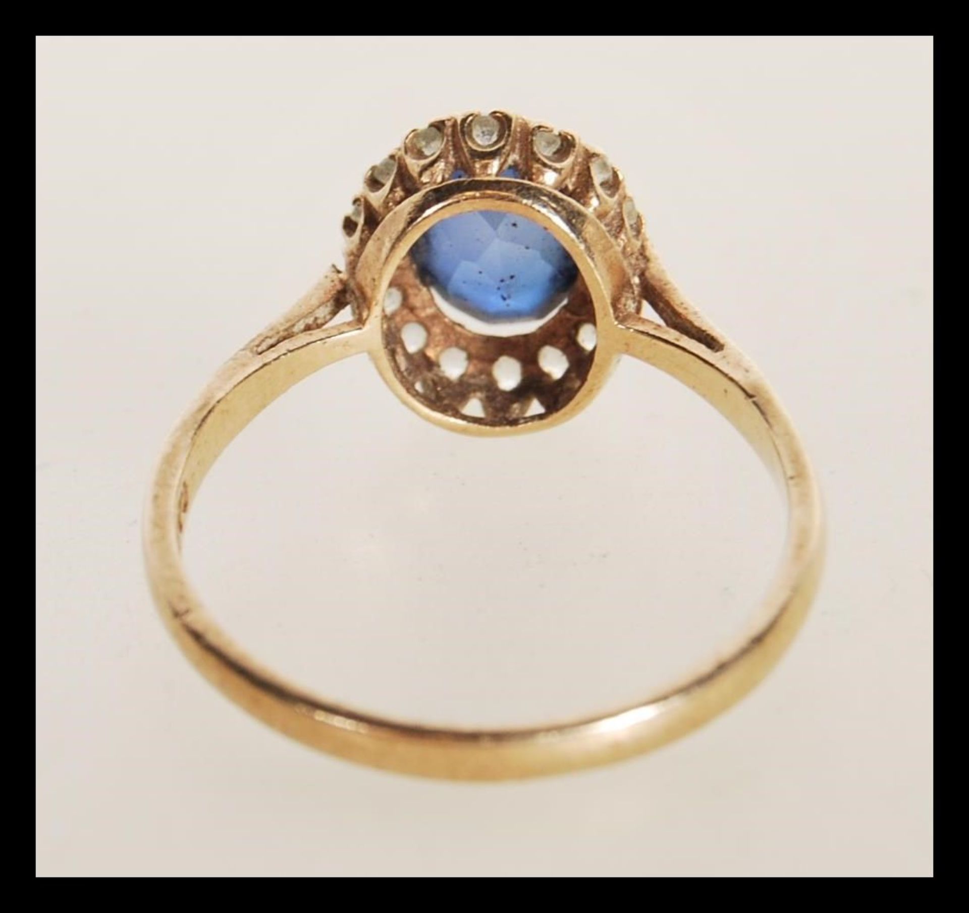 A hallmarked 9ct gold ring prong set with an oval cut synthetic sapphire set with a halo of white - Bild 3 aus 4