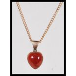 A 9ct gold necklace chain having a 9ct gold red stone set heart pendant. Weighs 5 grams. Chain