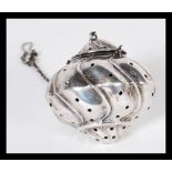 A 19th Century Chinese silver tea strainer of gadrooned form set in silver hook chain. Weighs 17.1