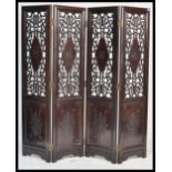 A large 20th Century Chinese padauk wood four panel folding discretionary screen room divider having