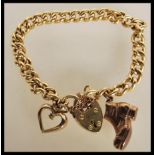 A 9ct gold hallmarked charm bracelet being adorned with boot, heart padlock and heart with