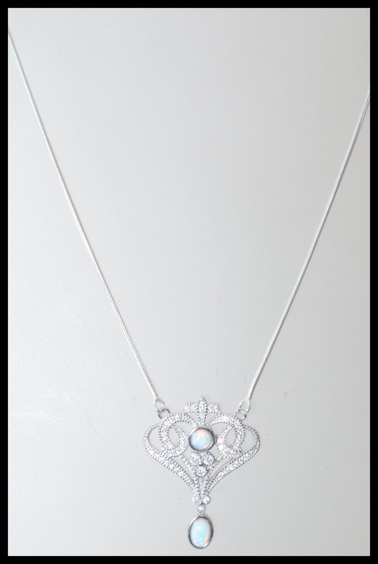 A stamped 925 silver necklace having an art nouveau style pendant set with cz's and opals, set to