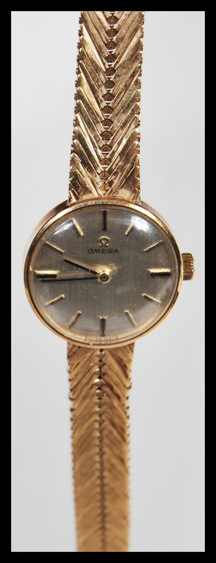 A vintage boxed Omega 9ct gold ladies watch set to a 9ct gold herringbone watch bracelet strap.