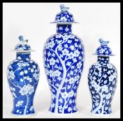 A collection of three 20th Century Chinese baluster lidded vases, having foo dog / temple dog