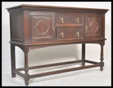 An early 20th Century geometric fronted Jacobean revival oak sideboard raised on block and turned