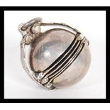 A sterling silver early 20th Century metamorphic locket pendant of orb form opening to reveal