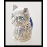 A stamped 925 silver pin cushion in the form of a cat having a black fabric cushion to the base, set