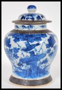 A 19th Century Chinese lidded jar or vase and cover having a crackle glaze ground with blue hand