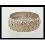 A hallmarked 9ct white gold ring with engraved patterning to the exterior. Hallmarked Birmingham