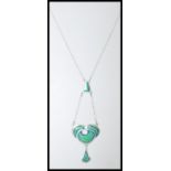 A stamped 925 silver necklace having an art nouveau style pendant with green enamel panels. Weight