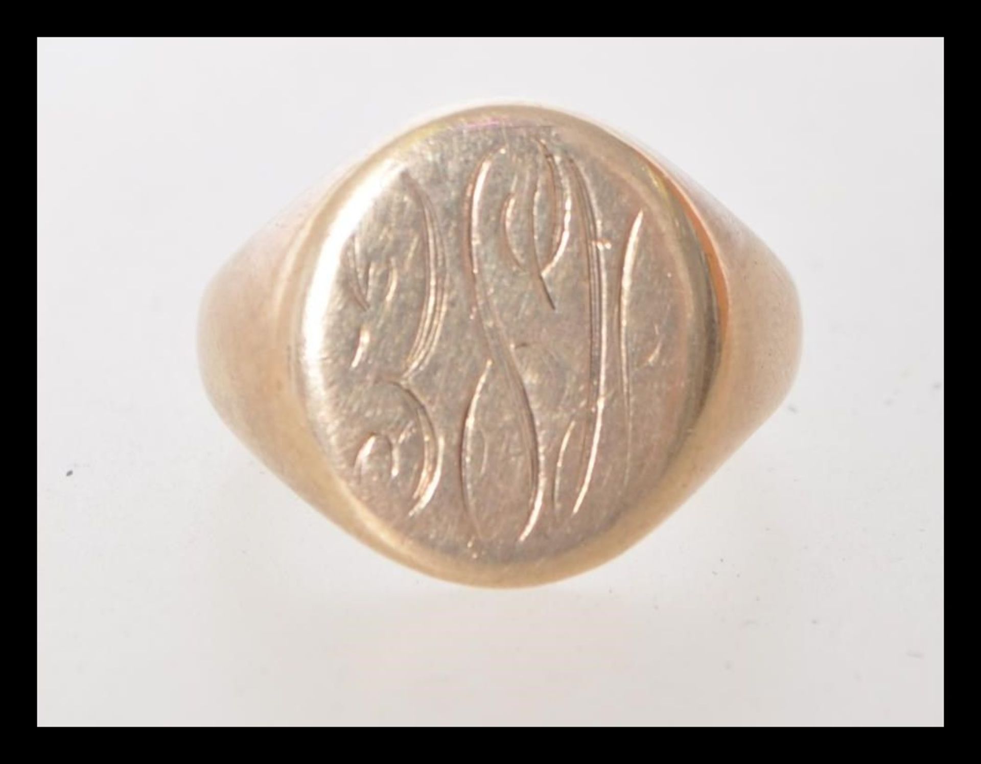 A hallmarked 9ct gold signet ring with a circular cartouche engraved with initials. Hallmarked