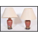 A pair of matching 20th Century Chinese ochre table lamps, the bulbous lamps raised on a pedestal