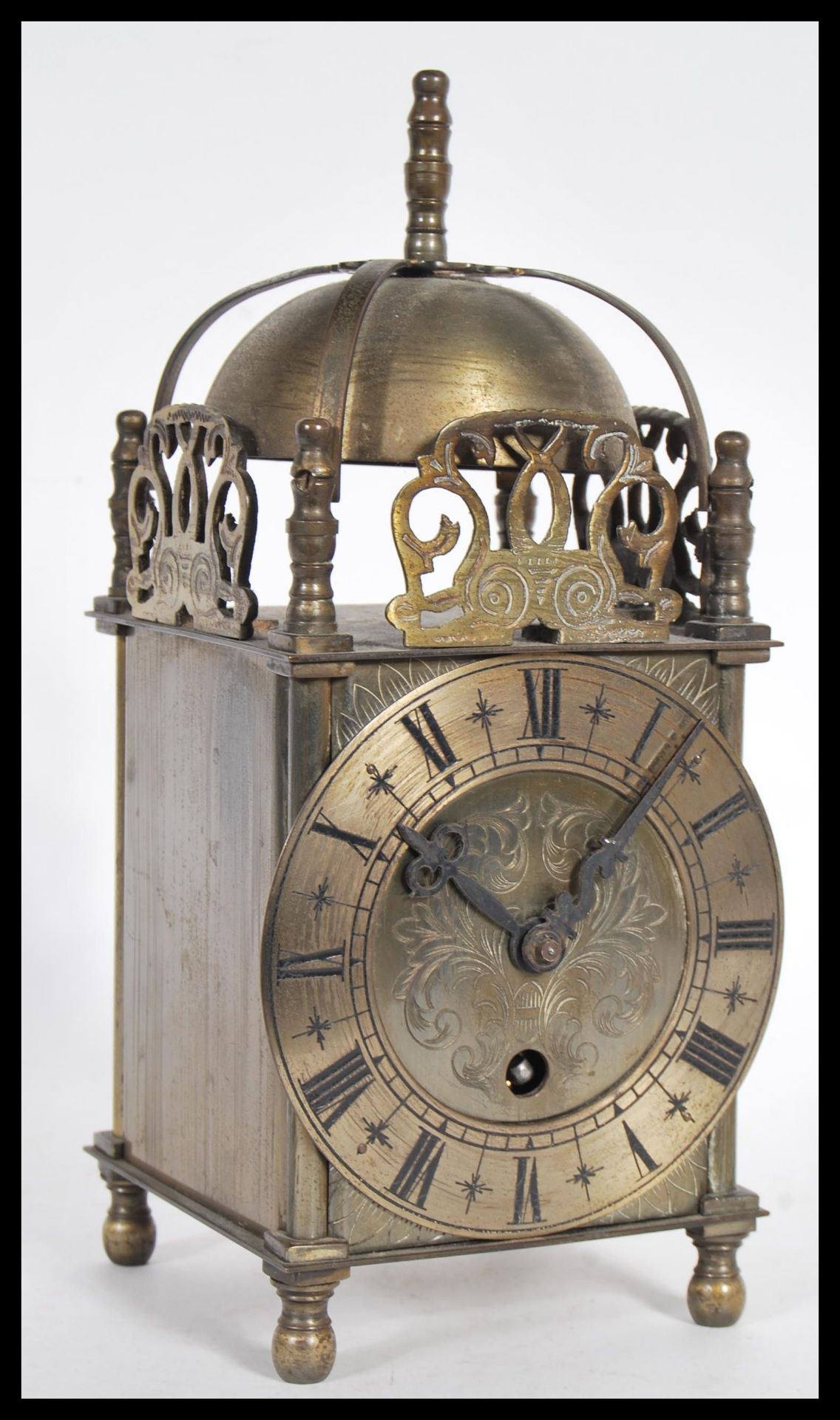 A 19th Century Victorian lantern clock having a pierced frieze with bell to top. The silvered dial