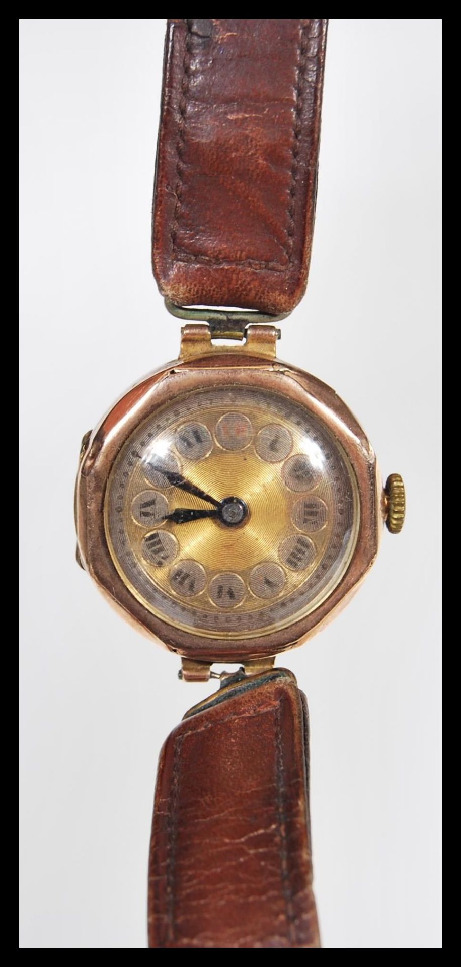 An early 20th Century Art Deco 9ct gold ladies wrist watch with a round face with a gilt dial,