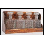 An early 20th Century four decanter set of tantalus manner square form having cut glass design